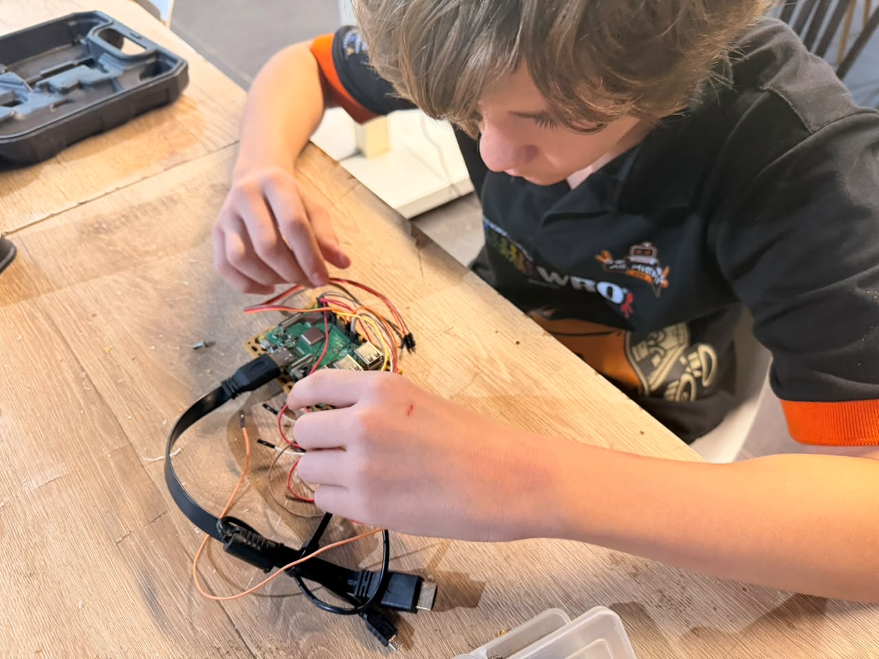 Miguel conectando os fios do Raspberry Pi